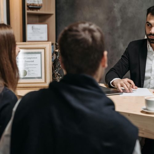 A lawyer in an elegant office meeting with clients, discussing documents.